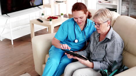 Enfermera-Ayudando-A-Una-Anciana-Jubilada-A-Usar-Su-Tableta