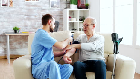Male-nurse-measuring-blood-pressure-of-a-man-pensioner