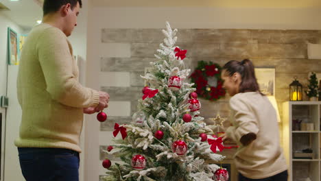 Couple-with-matching-clothes-decorate-their-christmas-tree
