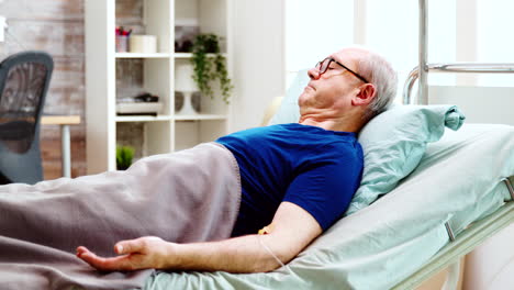 Portrait-of-elderly-sick-man-lying-in-hospital-bed