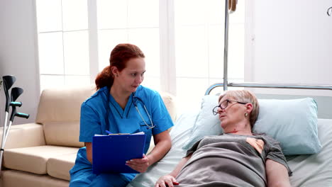 Female-nurse-taking-notes-on-clipboard-in-nursing-home