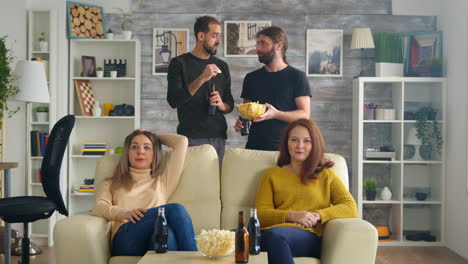 Group-of-friends-watching-a-football-match-in-living-room