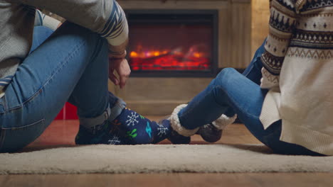 Young-couple-with-warm-socks-in-front-of-fireplace