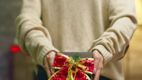Close-up-of-woman-showing-christmas-gift
