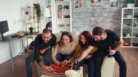 Group-of-friends-leaning-over-to-take-a-slice-of-pizza