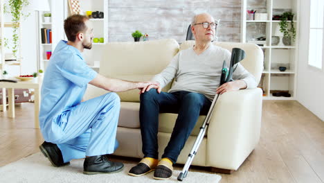 Revealing-shot-of-male-nurse-checking-on-retired-old-man-with-alzheimer