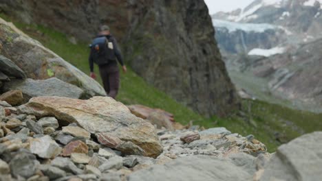 Male-Hiker-Climbing-Down-Over-Rocks-In-In-Valmalenco-Region-In-Italy