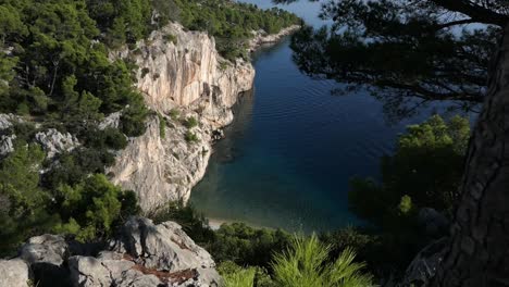 Breathtaking-hidden-paradise-beach-cove,-blue-sea-and-dramatic-mountain-cliffs