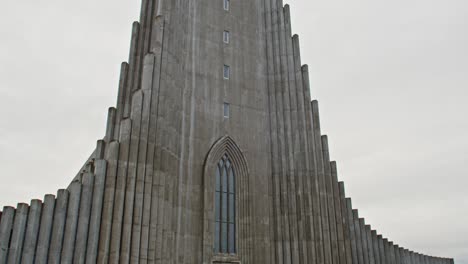 Tilt-up-from-people-entering-Hallgrímskirkja-church-to-the-tall-clock-tower-of-the-building
