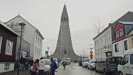 Wide-view-of-Hallgrímskirkja-Church-in-Reykjavik-with-tourists-roaming-on-the-street