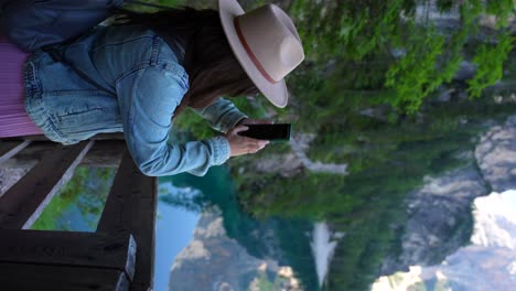 Mujer-Capturando-Fotografías-Con-Un-Teléfono-Inteligente-En-Lago-Di-Braies,-Dolomitas,-Italia