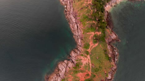 Overhead-aerial-drone-shot-of-Laem-Phromthep-Cape,-showing-the-length-of-the-peninsula-located-at-the-tip-of-Phuket-in-Thailand