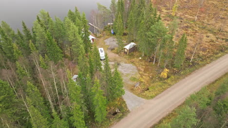 A-Road-In-Fir-Forest-With-A-Campervan-Parked-By-The-Lakeshore-In-Sweden-During-Autumn