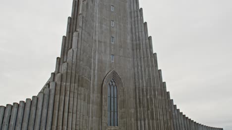 Tilt-down-from-tall-Hallgrímskirkja-church-tower-to-church-goers-in-front-of-entrance