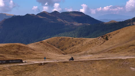 drone-shot-of-a-male-riding-motorbike-in-Nepal,-PikeyPeak,-hilly-region,-adventure-4K