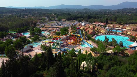Opening-Drone-Shot-of-A-Busy-Water-Park-During-a-Sunny-Summer-Day
