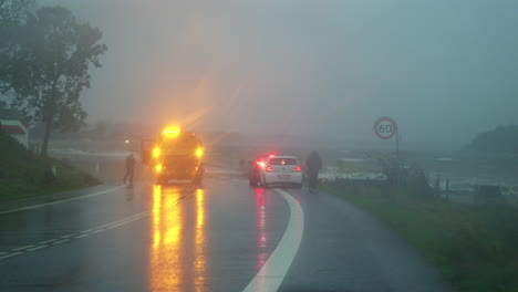 Emergency-response-to-storm-surge-in-Kollund,-with-vehicles-and-personnel-on-a-rainy-road