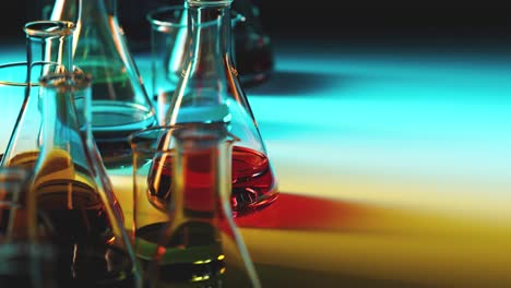 Seamless-looping-animation-of-laboratory-glassware-filled-with-colorful-liquids.-Multi-colored-light-passes-through-the-glass-beakers,-flasks-and-liquids-with-caustic-effect.-Concept-of-science,-lab
