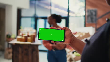 Local-merchant-showing-greenscreen-layout-on-phone