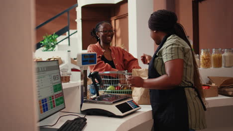 Retailer-placing-goods-on-electronic-scale-at-cash-register