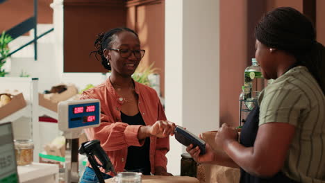 African-american-shopper-paying-with-card-at-cash-register
