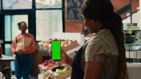 Small-business-owner-looking-at-phone-with-greenscreen