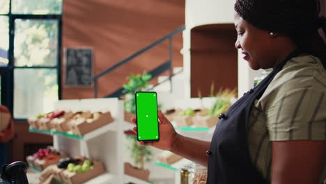 African-american-vendor-holding-phone-with-greenscreen