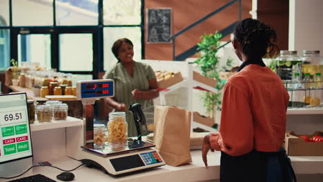 Local-merchant-placing-groceries-on-scale-at-cash-register