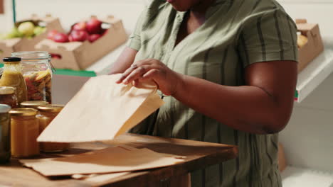 African-american-woman-pours-pasta-in-biodegradable-bag