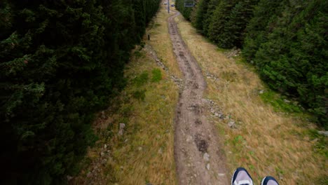 Cable-transport,-cable-car-going-down-the-mountain,-tilt-up-movement,-cloudy-weather,-Karpacz,-Poland