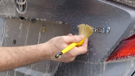 Cleaning-car-bagde-with-detailing-brush