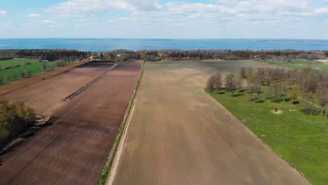 Aerial-Drone-Flying-Over-Oland-Island's-Agricultural-Farms-and-Kalmar-Strait