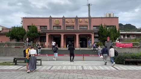 Tourists-take-photos-of-the-Ruifang-Train-Station,-frequented-by-visitors-traveling-to-Jiufen,-Pingxi,-and-other-destinations-in-Taipei,-Taiwan