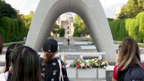 Turistas-Tomando-Fotos-Con-Teléfonos-Inteligentes-En-El-Cenotafio-Conmemorativo-De-Las-Víctimas-De-Hiroshima,-Japón
