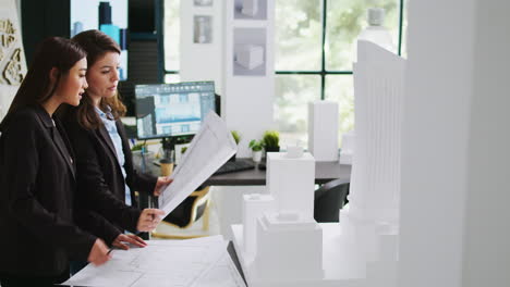 Architects-team-studying-3d-printed-building-model-in-office