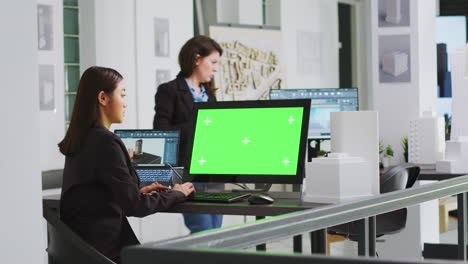 Architect-using-computer-with-greenscreen-at-workstation