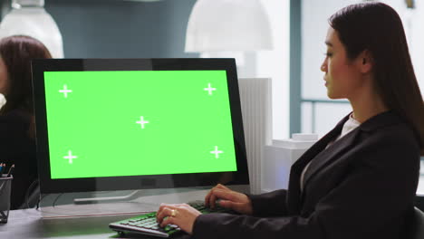 Cad-designer-using-PC-with-greenscreen-at-workstation-area