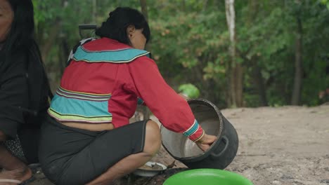 2-Mujeres-Limpiando-Ollas-Con-Las-Manos-En-La-Selva-Amazónica