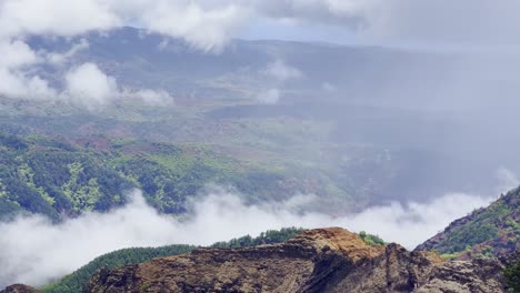 Cinematic-long-lens-shot-panning-shot-of-colorful-Waimea-Canyon-with-some-cloud-cover-on-the-island-of-Kaua'i-in-Hawai'i