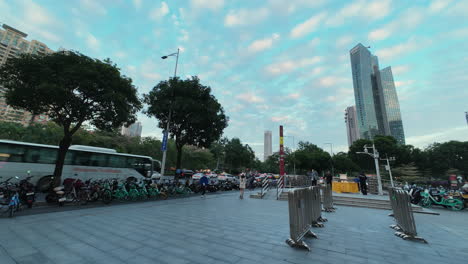 Timelapse-of-Busy-heavy-traffic-and-of-Guangzhou-city,-next-to-the-metro-station-exit-with-people-walking-in-and-out-on-a-beautiful-sunset