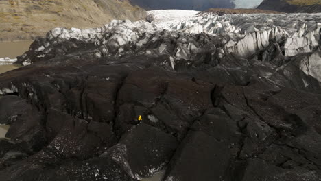 Svinafellsjokull-Glacier,-Iceland---A-Man-Strolling-on-the-Glacier---Aerial-Drone-Shot