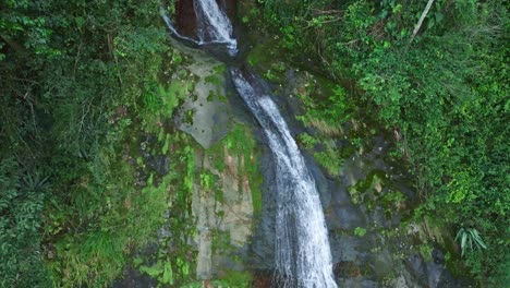 Toma-Aérea-De-Arriba-Hacia-Abajo-De-Una-Cascada-Que-Fluye-En-La-Selva-Verde-De-Bonao,-República-Dominicana