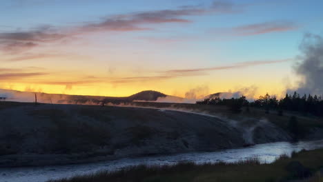 Grand-Prismatic-Spring-dusk-sunset-mist-steam-landscape-West-Yellowstone-National-Park-Old-Faithful-Grand-loop-geysers-scenic-Wyoming-Idaho-thermal-colorful-yellow-midday-cinematic-slowly-pan-left