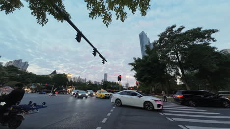 Timelapse-of-Busy-heavy-traffic-intersection-with-people-crossing-over-the-road-in-the-evening-on-a-beautiful-sunset