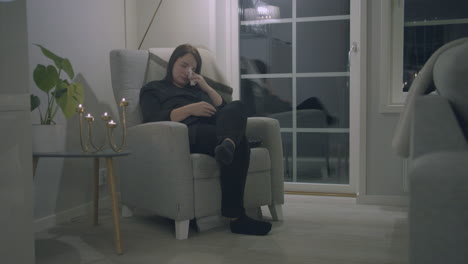 Pregnant-woman-sitting-in-armchair-crying