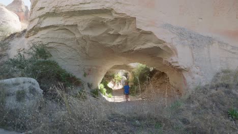 Female-Hiker-explores-natural-rock-cave-Red-valley-trail-Cappadoccia