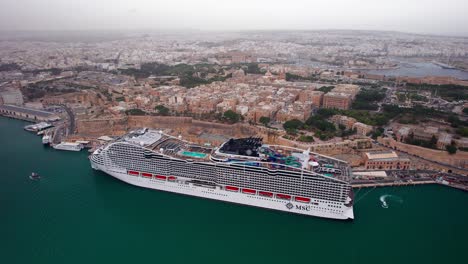 Crucero-World-Europa-Msc-En-El-Gran-Puerto-De-Malta,-Con-La-Valleta-Al-Fondo