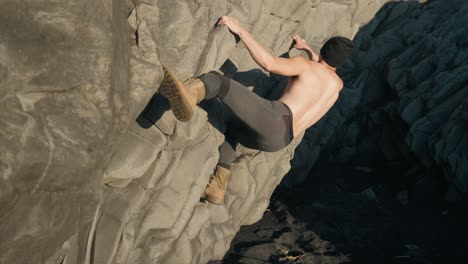 A-young-asian-male-is-rock-climbing-in-Iceland-during-daytime