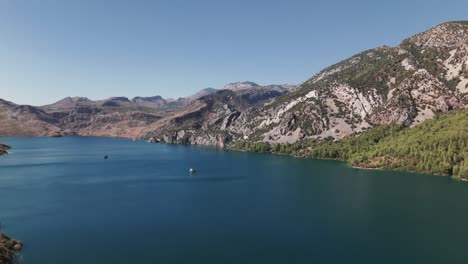 Barcos-Anclados-En-Hermosas-Aguas-Azules-Profundas-En-La-Base-Del-Impresionante-Cañón-Verde,-Montañas-Tauro,-Turquía