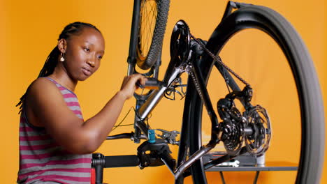 Engineer-checking-bicycle-performance-by-spinning-bike-wheel-during-maintenance